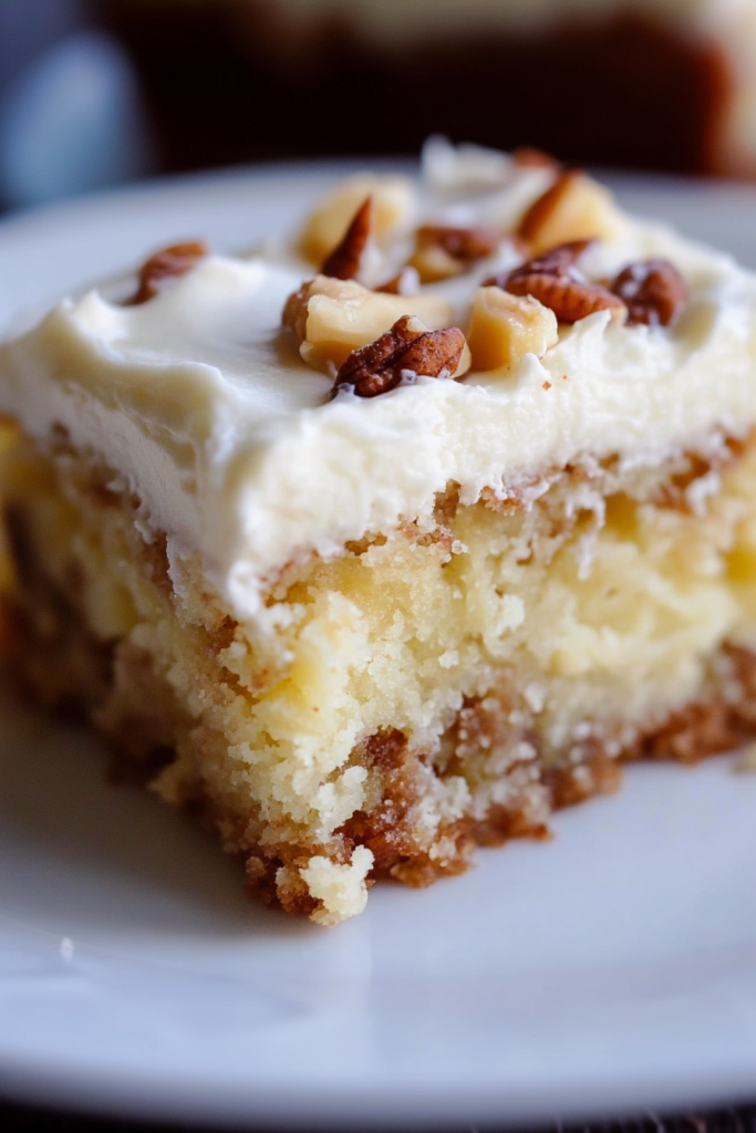 Close-up of moist vanilla cake layered with smooth icing and crunchy nut topping.