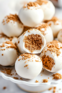 Close-up of a bitten truffle revealing its crumbly cookie interior against the smooth coating.