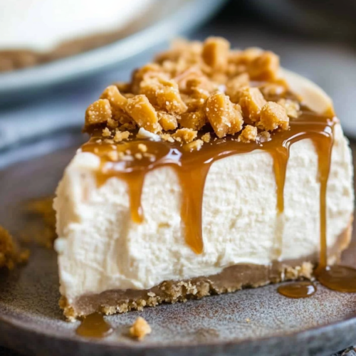 Close-up of a sliced cheesecake showing its smooth filling, crumbly crust, and caramel topping.