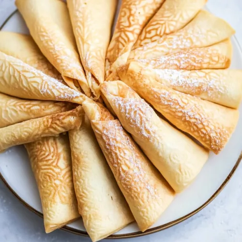Close-up of crisp, patterned cookies highlighting their traditional shape.