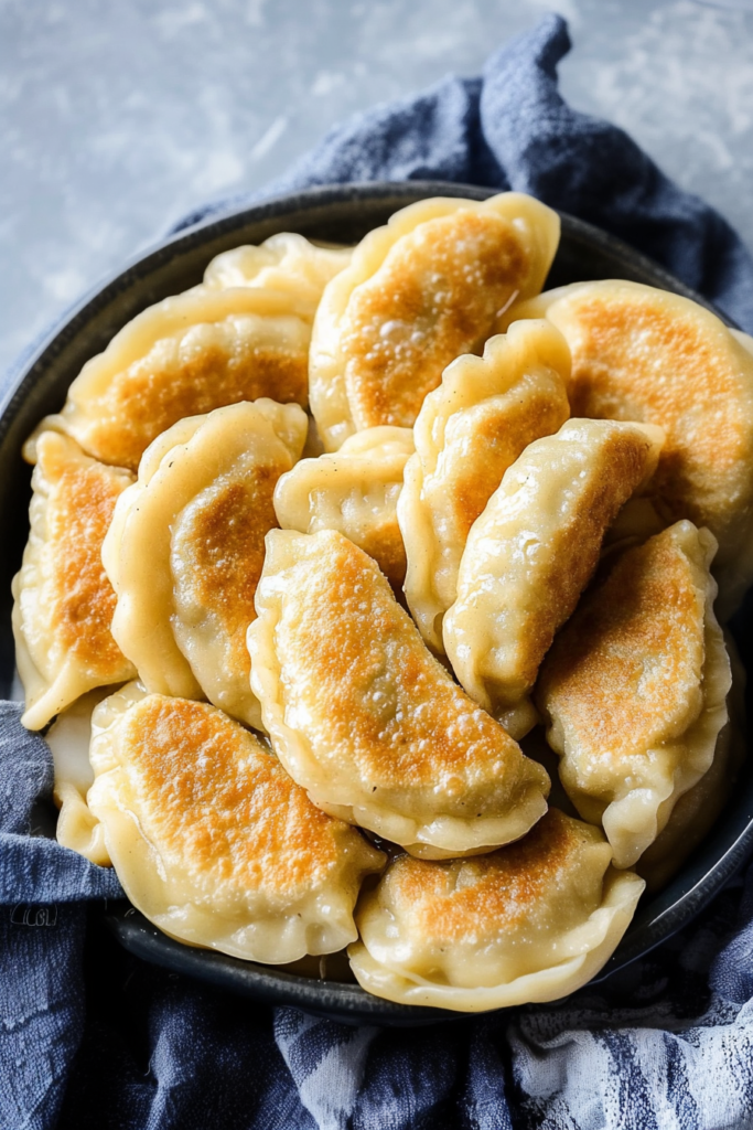 Homemade pierogi with lightly browned edges stacked in a rustic bowl.