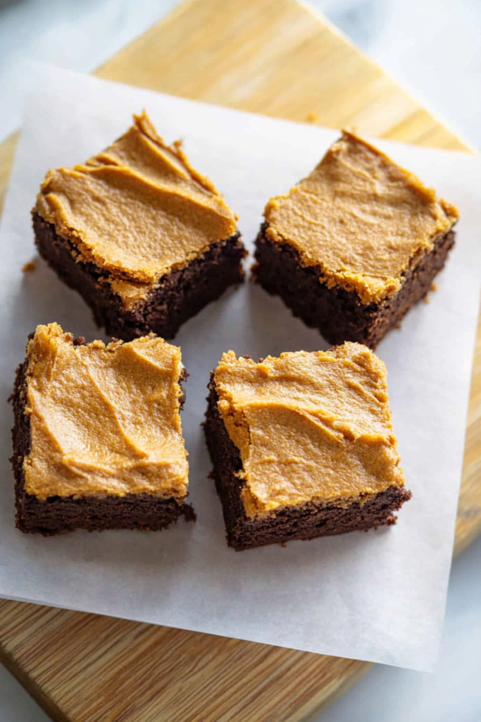 Freshly baked brownie squares with a thick pumpkin topping and deep chocolate base.