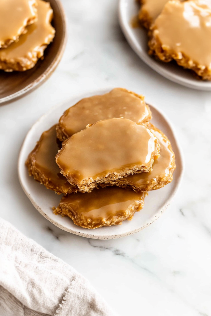 Caramel-colored pralines with glossy finish, one piece broken to show texture.