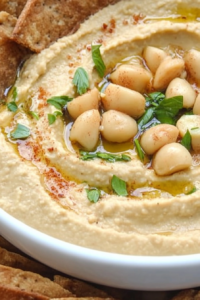 Roasted garlic hummus finished with parsley and pita wedges around the edge.