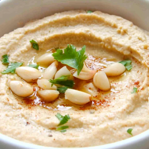 Rustic bowl of Middle Eastern dip with olive oil and paprika for color.