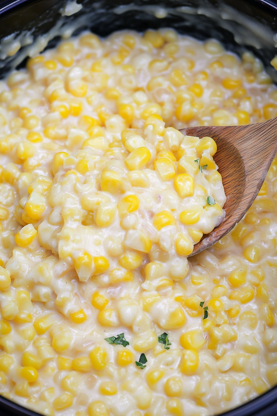 Golden corn in a creamy cheddar sauce, garnished lightly with herbs.