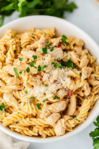 Rotini pasta with chicken in a smooth garlic-Parmesan sauce, finished with a sprinkle of parsley.