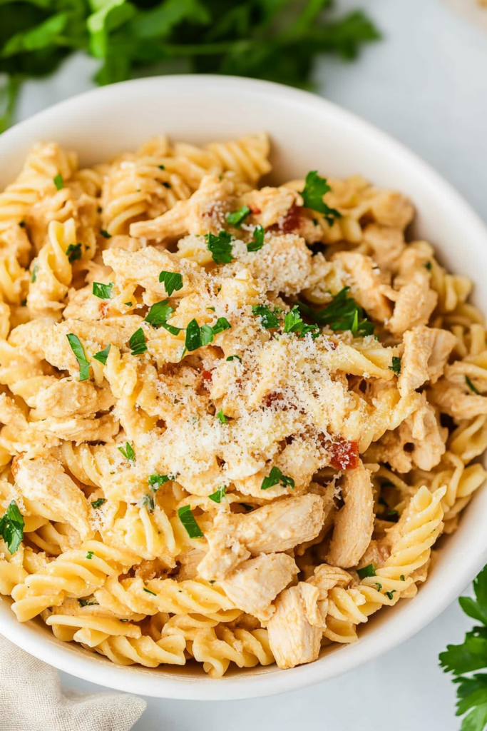 Rotini pasta with chicken in a smooth garlic-Parmesan sauce, finished with a sprinkle of parsley.