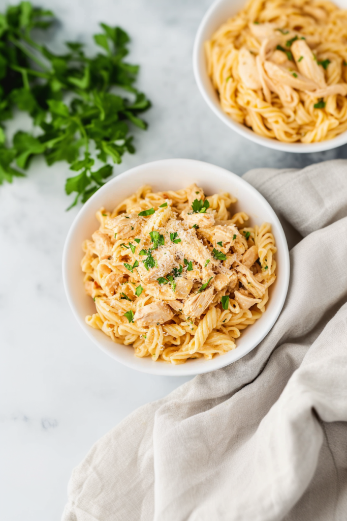 Freshly served pasta garnished with grated Parmesan and parsley, showing a hearty, comforting meal.