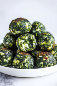 Cooked spinach mixture shaped into bite-sized balls with a rustic texture.