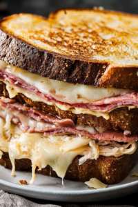 Close-up of a crispy toasted sandwich with layers of meat and gooey melted cheese