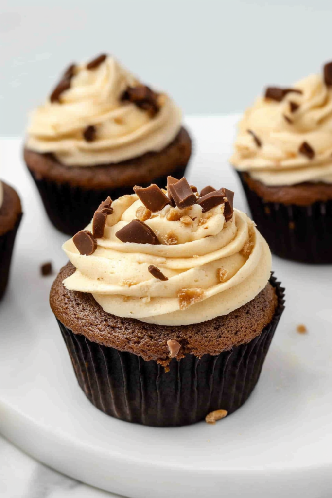 Chocolate cupcake with swirled frosting and sprinkled chocolate chunks.