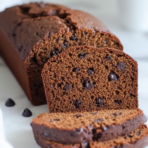 Close-up of dense brown bread showing rich texture and cracked crust.