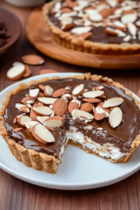 Flaky crust dessert filled with glossy chocolate, garnished with almonds for texture and flavor.