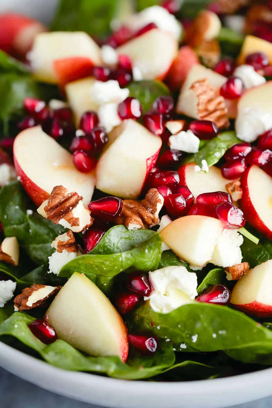 Healthy salad featuring sweet apples, toasted pecans, and bursts of pomegranate