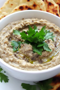Savory eggplant puree served in a bowl with fresh herb garnish