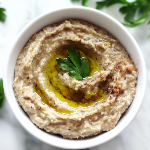 Creamy roasted eggplant dip topped with olive oil and fresh parsley