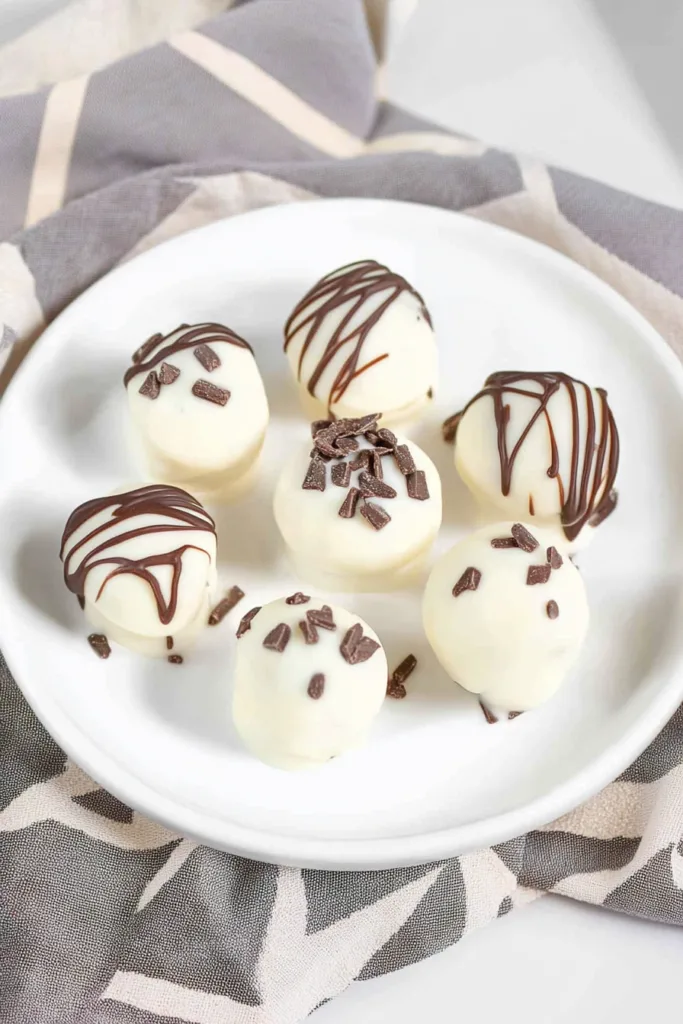 Final presentation of the recipeโs dessert balls, highlighting contrast between white and dark chocolate.