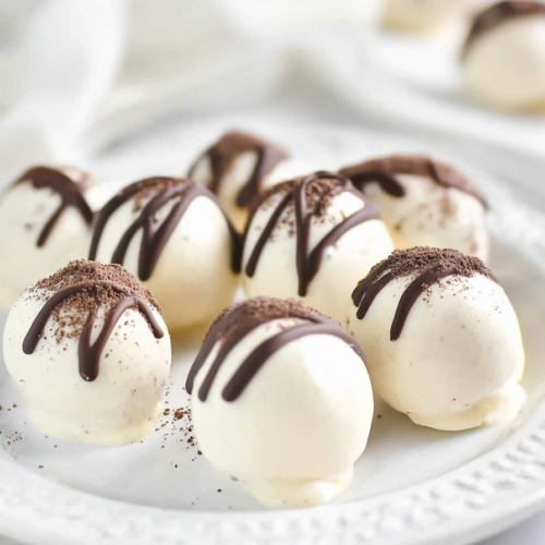 Round dessert bites arranged neatly on a decorative plate with a soft, clean background.