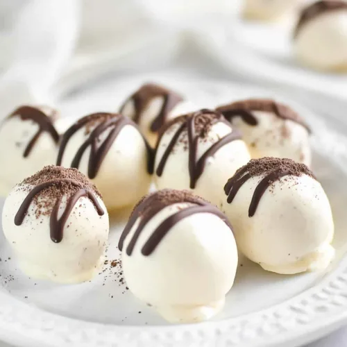 Round dessert bites arranged neatly on a decorative plate with a soft, clean background.