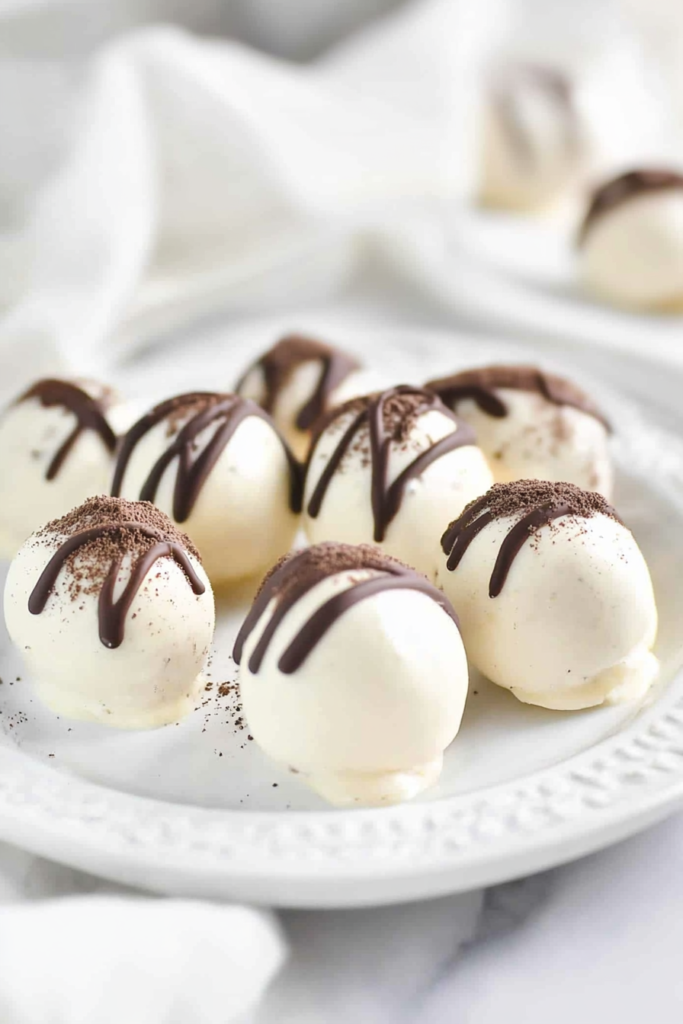 Round dessert bites arranged neatly on a decorative plate with a soft, clean background.