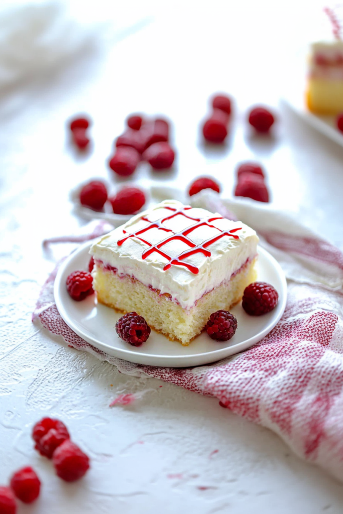 Final plated dessert showcasing light sponge, vibrant fruit filling, and smooth frosting.