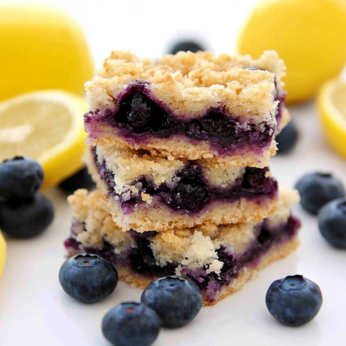 Stacked crumb bars with golden crust and vibrant blueberry filling.