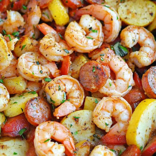 Final plated dish showing seasoned shrimp and sausage nestled among roasted potato slices.