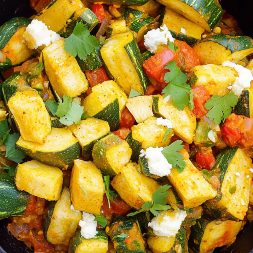 Freshly cooked squash and zucchini medley topped with herbs and creamy cheese cubes.