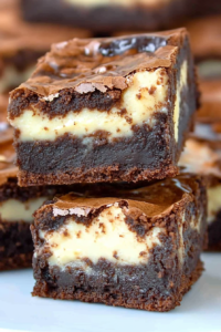 Neatly cut brownies revealing dense chocolate base and creamy yellow center.