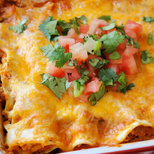 Hearty chicken and tortilla bake with gooey cheese and tomato garnish.