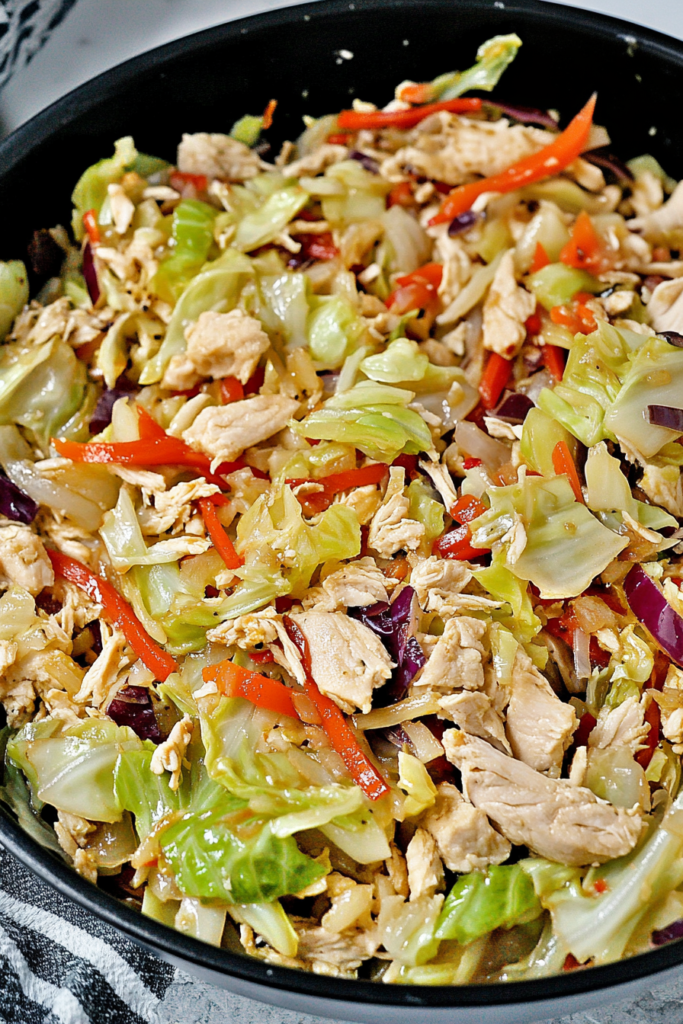 Freshly cooked chicken mixed with sautรฉed cabbage and vegetables in a savory sauce
