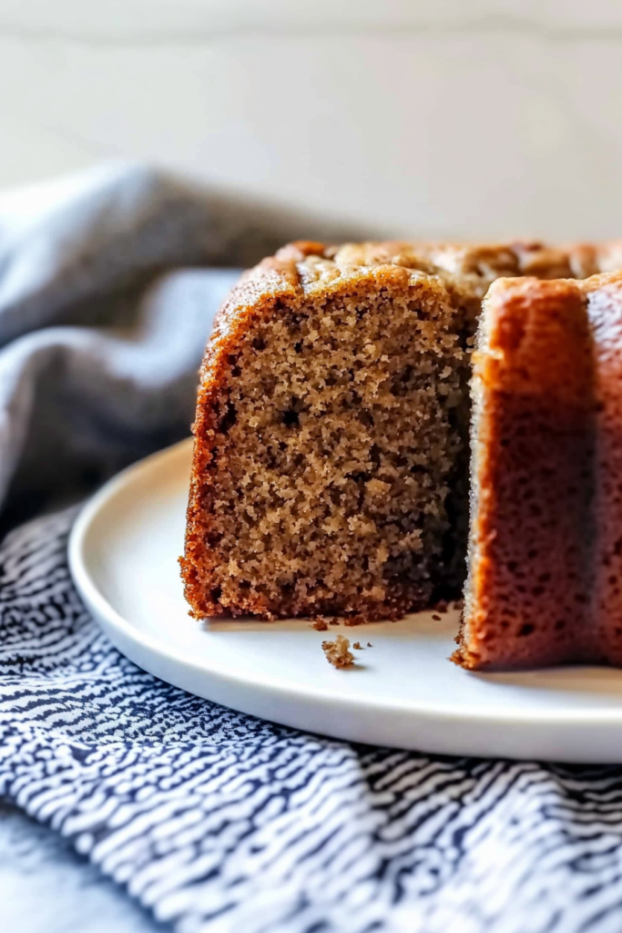 Sliced loaf of moist banana bread with walnuts and chocolate chunks on a white plate