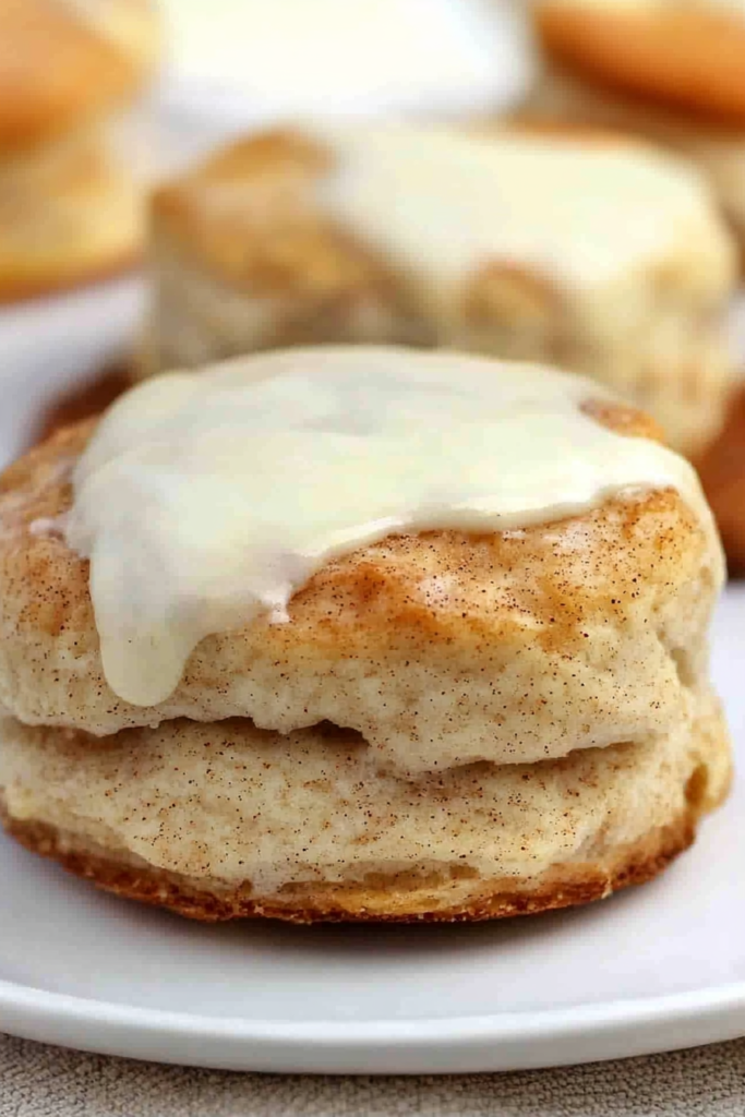 Rustic baked biscuit paired with another in the background, showcasing rich texture and icing.