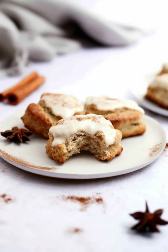 Golden-brown biscuit topped with a smooth layer of icing on a white plate.