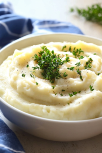 Light and fluffy mashed potatoes served warm with butter and fresh herbs.