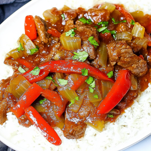 Tender beef strips cooked in a rich savory sauce with sliced bell peppers, served over white rice.