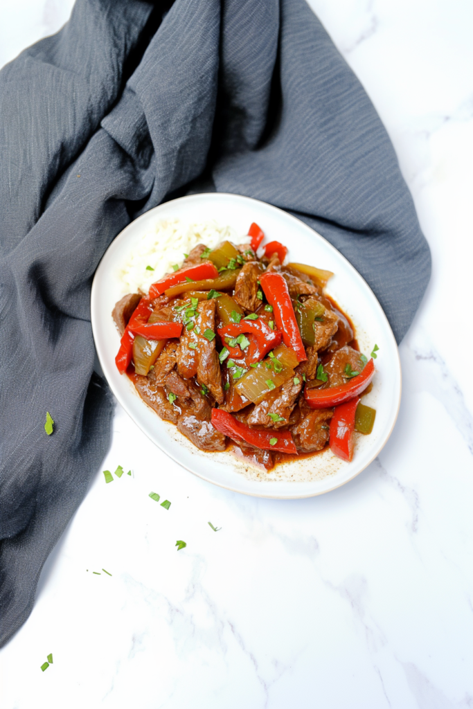 Juicy beef pieces simmered with onions and bell peppers in a flavorful sauce.