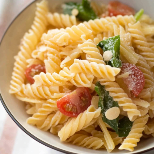 Simple pasta dish with olive oil sheen, fresh vegetables, and rustic presentation