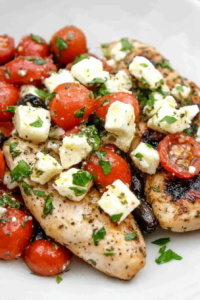 Close-up of seasoned chicken served with a fresh tomato herb mixture