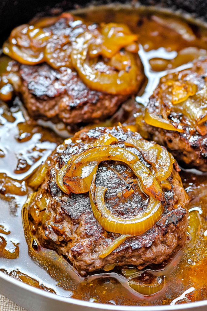 Pan-seared beef medallions covered in tender onions and flavorful sauce
