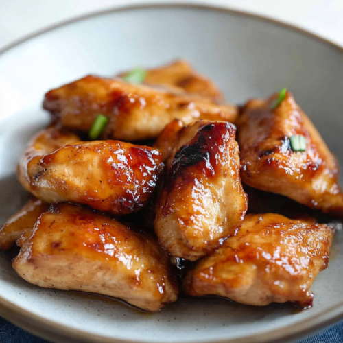 Sweet and savory chicken bites coated in sticky teriyaki sauce, close-up serving