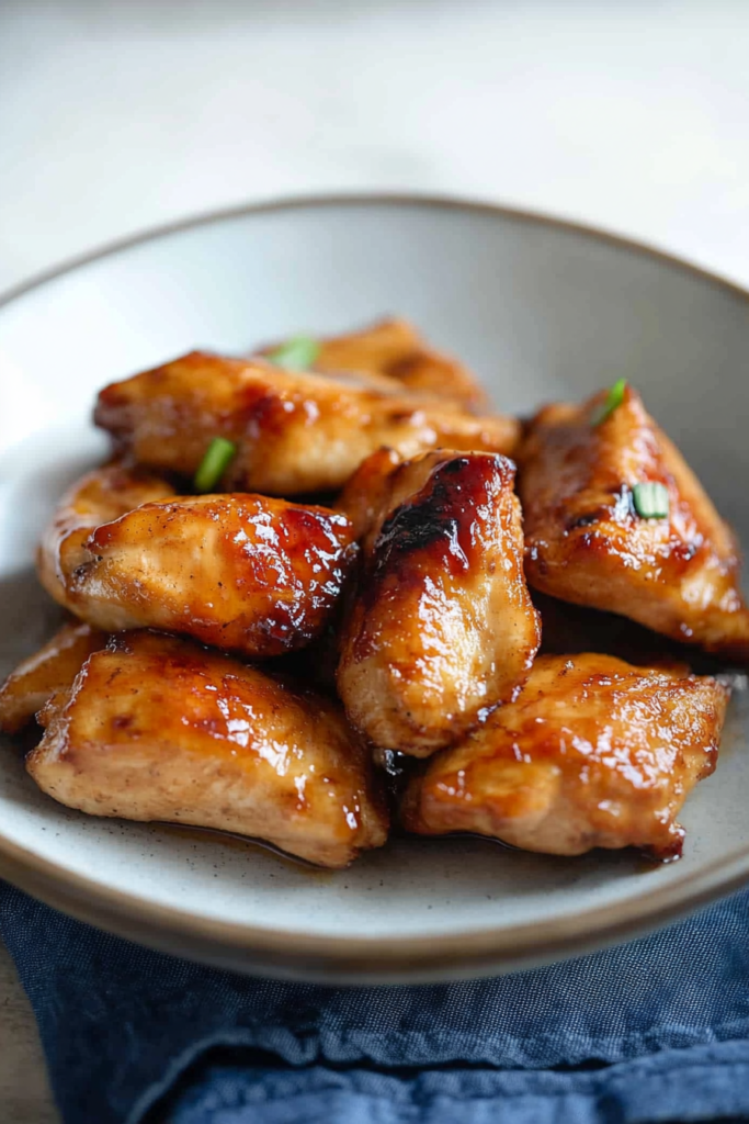 Sweet and savory chicken bites coated in sticky teriyaki sauce, close-up serving