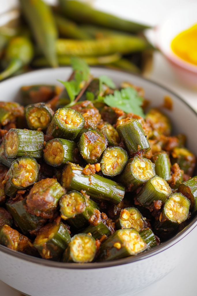 Close-up of chopped okra cooked with aromatic spices in a thick savory sauce.