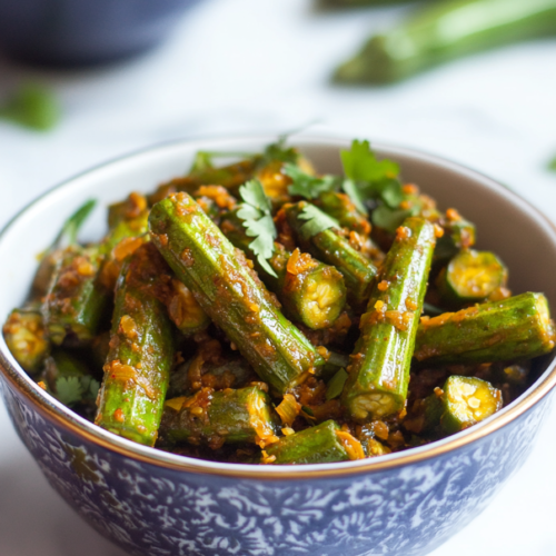 Spiced okra dish served in a bowl with visible mustard seeds and masala coating.