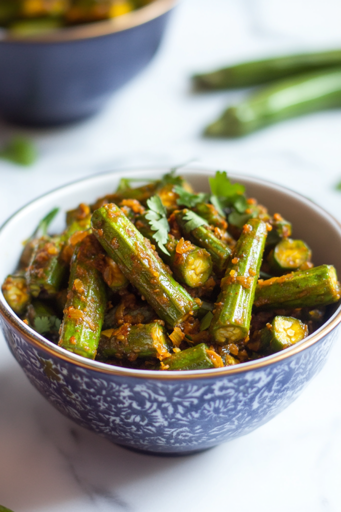 Spiced okra dish served in a bowl with visible mustard seeds and masala coating.
