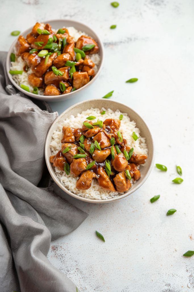 Juicy chicken cubes in a sweet and savory glaze, garnished with green onions and sesame seeds