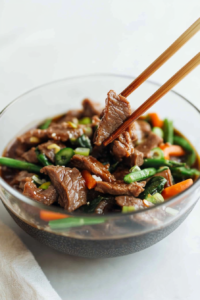 Juicy sliced beef coated in rich brown sauce with carrots and green beans.
