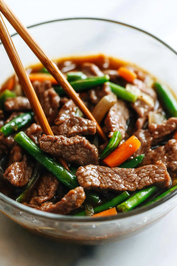 Close-up of saucy Asian-style beef stir fry served with crisp vegetables.