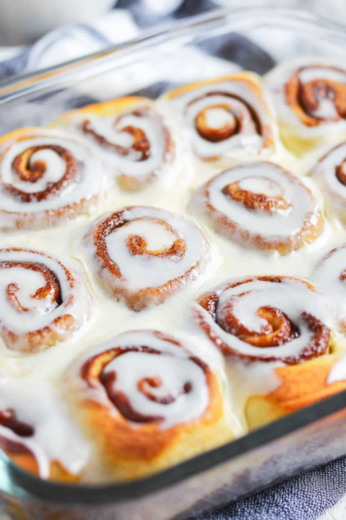 Freshly baked rolls with a fluffy texture, creamy icing, and warm cinnamon filling.